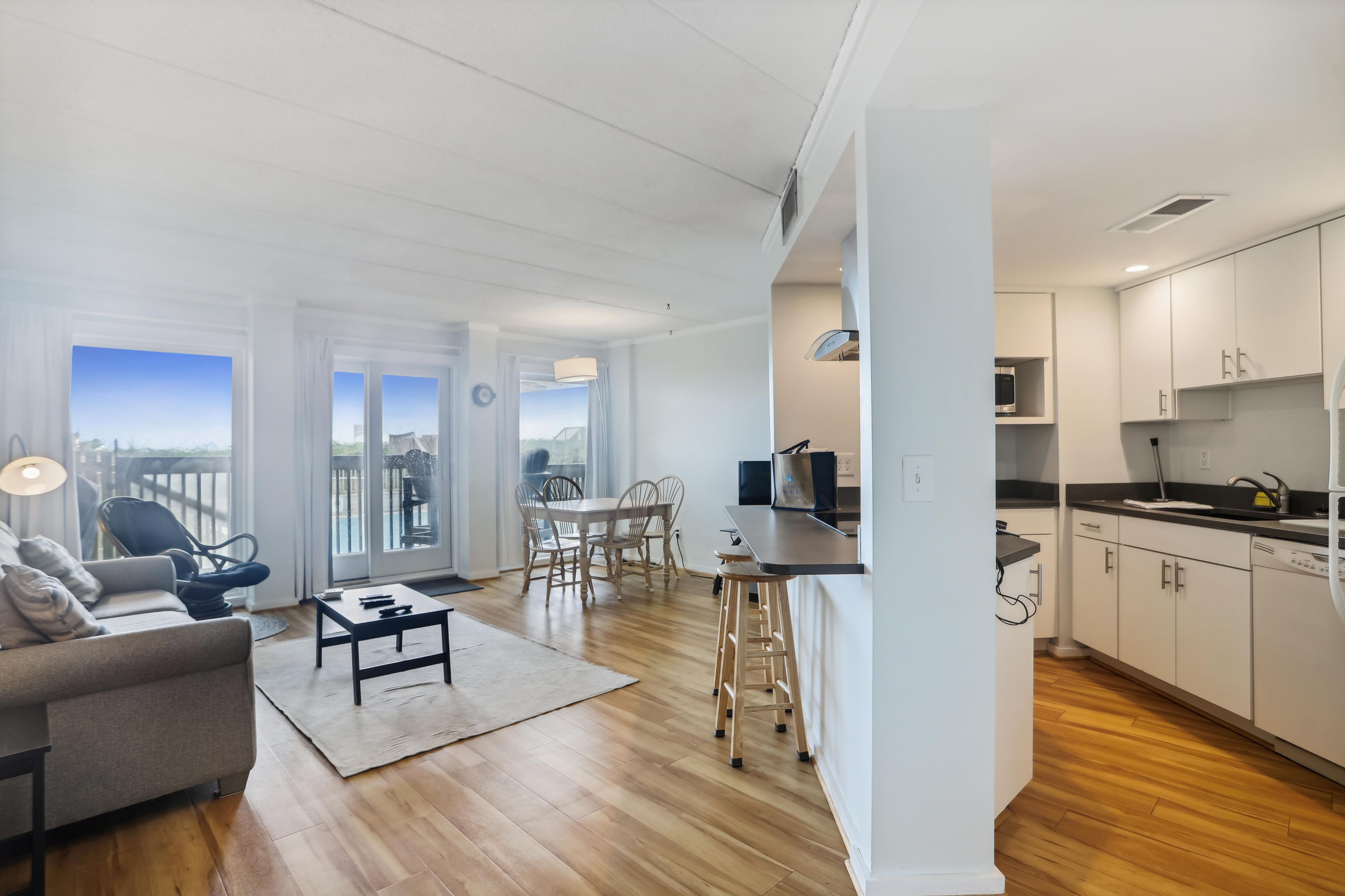 Un apartament modern amb zona de menjador, cuina i un balcó que ofereix vistes a la ciutat.