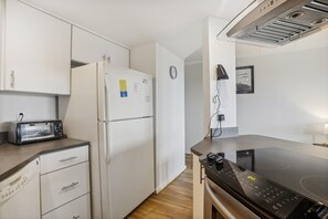 A kitchen with white cabinets, a built-in oven, a microwave, and a toaster. - The Oceans Unit 301 -- Oceanfront Condo with Direct Access to Pool and Beach (Nags Head)