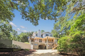 A two-story house with a covered porch and a staircase leading to the upper level. - Leeward Inn-- Beautifully Decorated Home with Pool, Hot Tub and More! (Southern Shores)