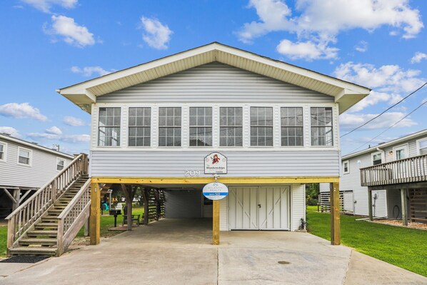 A two-story building with a covered porch and a staircase leading to the upper level.