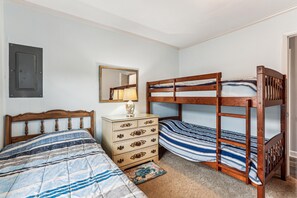 Ein Schlafzimmer mit zwei Etagenbetten, einem Schminktisch, einem Spiegel und einer Tür.
