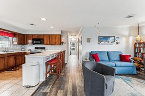 Une cuisine moderne avec des meubles en bois, un îlot central et un coin repas avec des chaises.