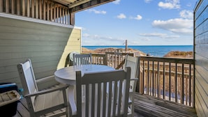 A covered outdoor seating area with a view of the beach and ocean. - Seawalk Unit 8 -- Oceanfront Townhouse with Pool Access (Kill Devil Hills)