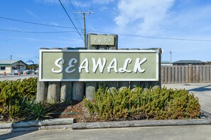 En träskylt med namnet ”SEAWALK” och siffran ”2035” ovanför, omgiven av grönska.