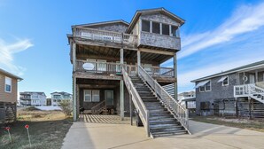 A multi-story building with a central staircase, balconies, and a covered porch area. - Miller Cottage -- Semi OF Home in Kitty Hawk with Hot Tub (Kitty Hawk)