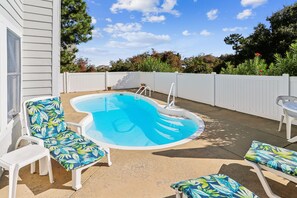 A backyard with a swimming pool, lounge chairs, and a white fence. - Tax D'Ducktion-- 6BR Oceanside home in Downtown Duck with Pool (Duck)