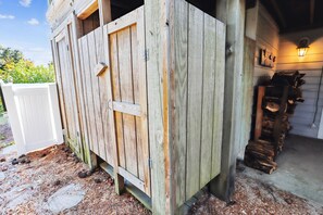 A wooden shed with a door and a window, a white fence, and a stack of firewood. - Tax D'Ducktion-- 6BR Oceanside home in Downtown Duck with Pool (Duck)