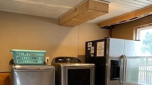A compact laundry room with a washing machine, dryer, and refrigerator. - Flamingo -- Pet Friendly Home with Private Pool and Gameroom (Nags Head)