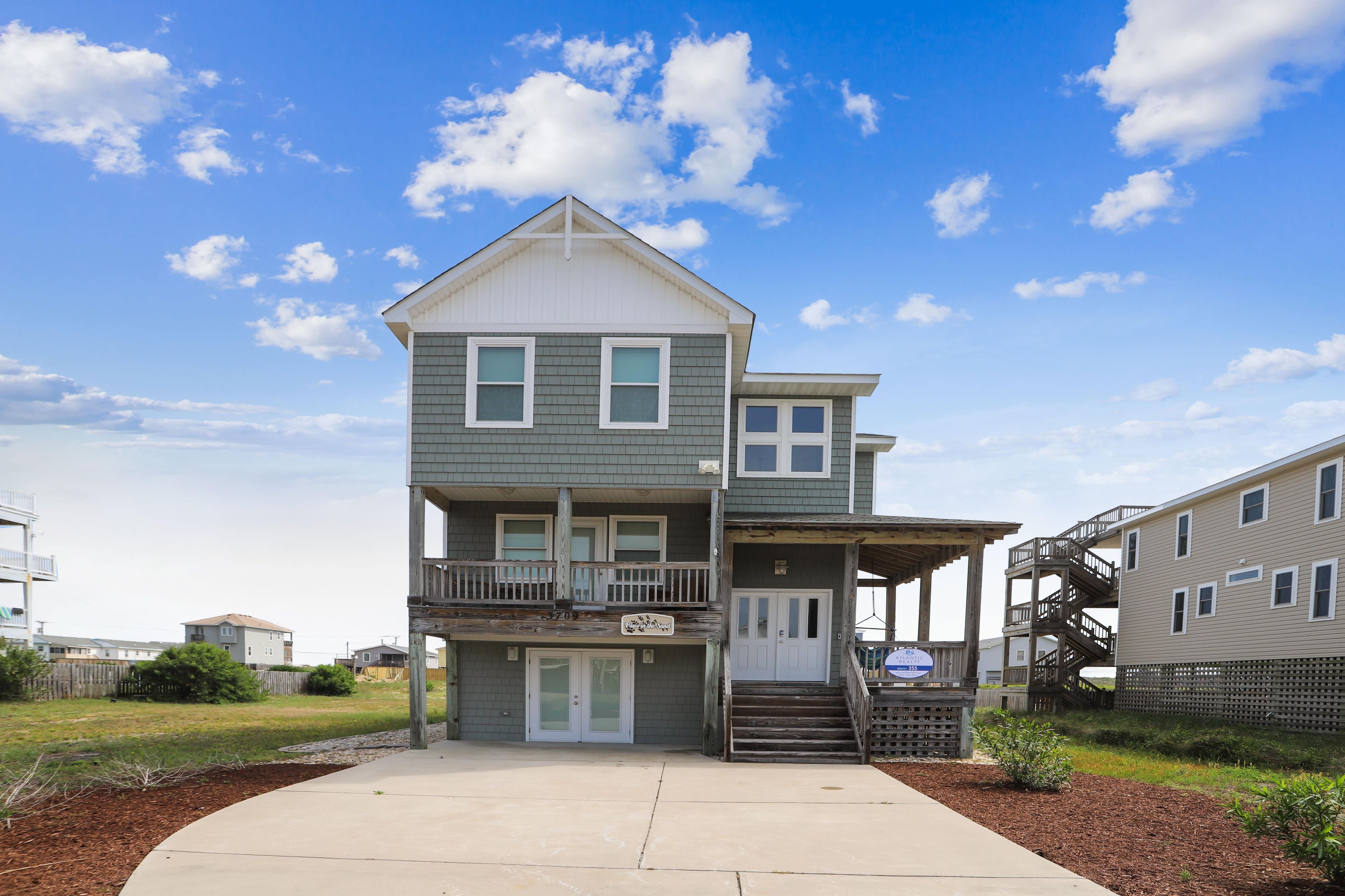 A two-story residential building with a balcony and a covered porch.