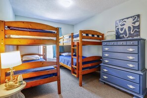A room with bunk beds, a dresser, and a lamp. - Ola Corolla -- Pet Friendly Oceanside home with Pool, Hot Tub (Corolla)