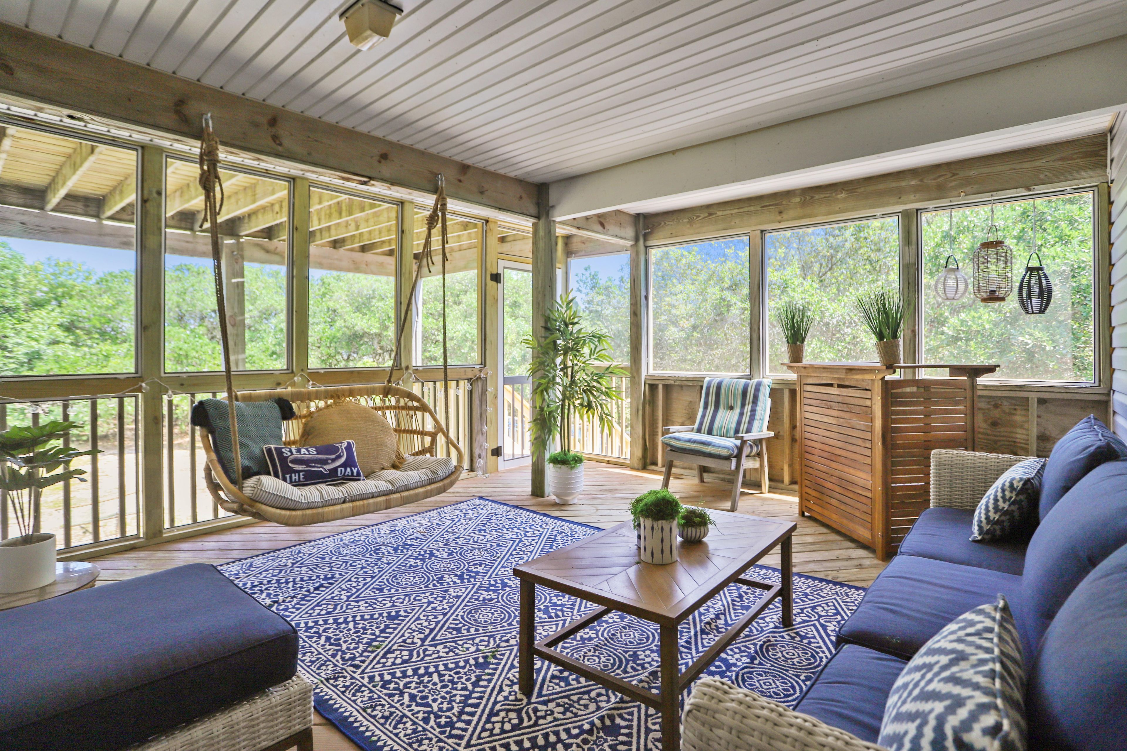 An open-plan living area with a hanging chair, sofa, and a coffee table.
