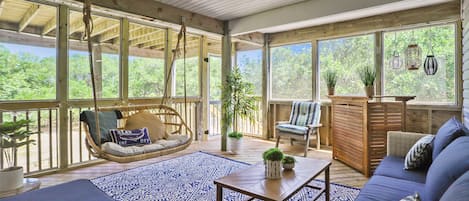 An open-plan living area with a hanging chair, sofa, and a coffee table.