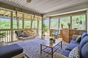 An open-plan living area with a hanging chair, sofa, and a coffee table. - Ola Corolla -- Pet Friendly Oceanside home with Pool, Hot Tub (Corolla)