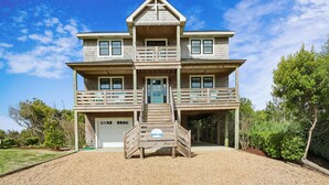 A two-story house with a front porch, a garage, and a driveway.