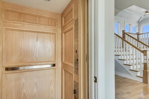 A wooden door with a digital keypad and a small window. - Fantasea -- Spectacular Semi OF Home in Kitty Hawk w/Elevator, Pool and Ocean Views (Kitty Hawk)