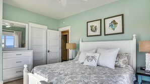Un dormitorio con cama, cómoda, espejo y dos cuadros en la pared.