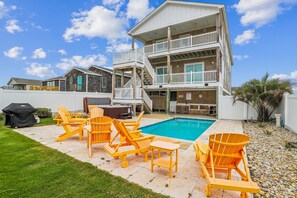 A two-story building with a pool, outdoor seating, and a covered barbecue area. - Fantasea -- Spectacular Semi OF Home in Kitty Hawk w/Elevator, Pool and Ocean Views (Kitty Hawk)