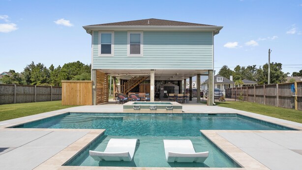 Ein zweistöckiges Haus mit einem Garten und einem Pool.
