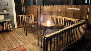 An outdoor patio area with string lights, a fire pit, and wooden furniture. - The Dragonfly- A Historic Gem with Hot Tub (Franklin)