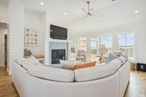 A living room with a fireplace, a large sofa, and a television.