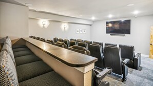 Une salle de conférence avec une longue table et des rangées de chaises, un téléviseur à écran plat fixé au mur, et une porte sur le côté droit.