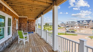 A wooden deck with a view of a residential area and construction vehicles. - Newbern - New Cons. Semi Oceanfront in Corolla with Fire Pit, Elevator, Hot Tub and More! (Corolla)