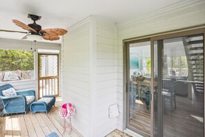 A covered porch with wicker furniture, a ceiling fan, and a sliding glass door leading to an outdoor area. - House of Friends -- New Listing!  Private Pool, Easy Beach Access (Kitty Hawk)