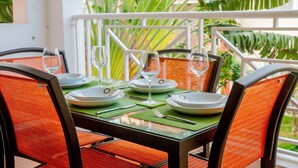 Une table dressée pour six personnes, avec des sets de table verts, des assiettes blanches et des verres à vin transparents.