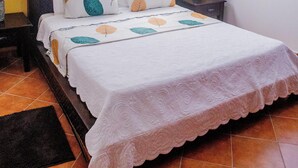 Une chambre à coucher avec un lit, un ventilateur de plafond, une fenêtre et un appareil de climatisation.
