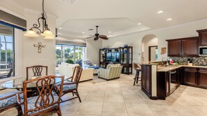 A spacious living area with a dining table, chairs, and a TV.