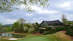 A golf course with a house in the background. - Cozy King Room in Clayton with Mountain Views and Communal Pool (Clayton)