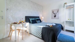 A bedroom with a bed, bedside table, and a chair.