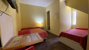 A small, compact room with two single beds, a wooden table, and a chair. There is a small window providing natural light, and a wall-mounted TV. - Mitre Suites Hotel (Buenos Aires)