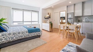 Un appartement moderne comprenant une chambre, un coin repas et une cuisine.