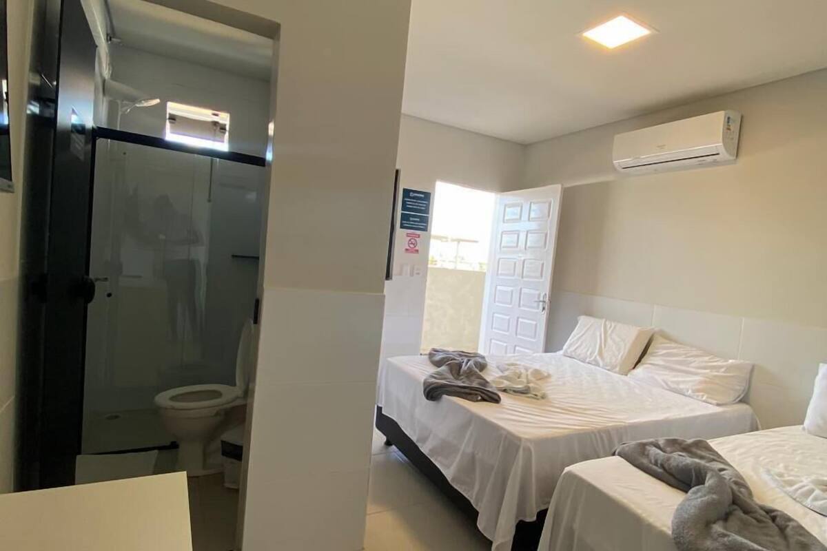 Ein Hotelzimmer mit zwei Betten, einer Dusche und einer Klimaanlage.