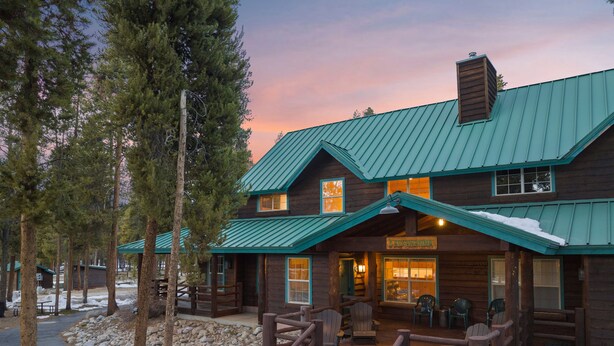 A rustic lodge with a green metal roof, wooden exterior, and a sign reading "Lacawanna."