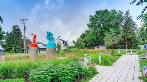 A pathway leading to a park area with statues and greenery. - Le Patrimonial-Two bedrooms 6 persons (Québec City)