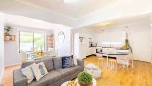 A modern apartment with a dining area, a kitchen, and a living room. - Silver Sands, 29 Victoria Pde water views and across the road to the water (Nelson Bay)