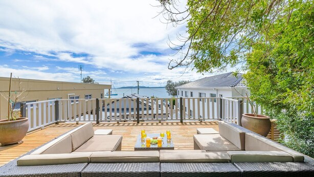 A rooftop terrace with outdoor seating, a view of the sea, and a white fence. - Silver Sands, 29B Victoria Pde - across the road to the water (Nelson Bay)
