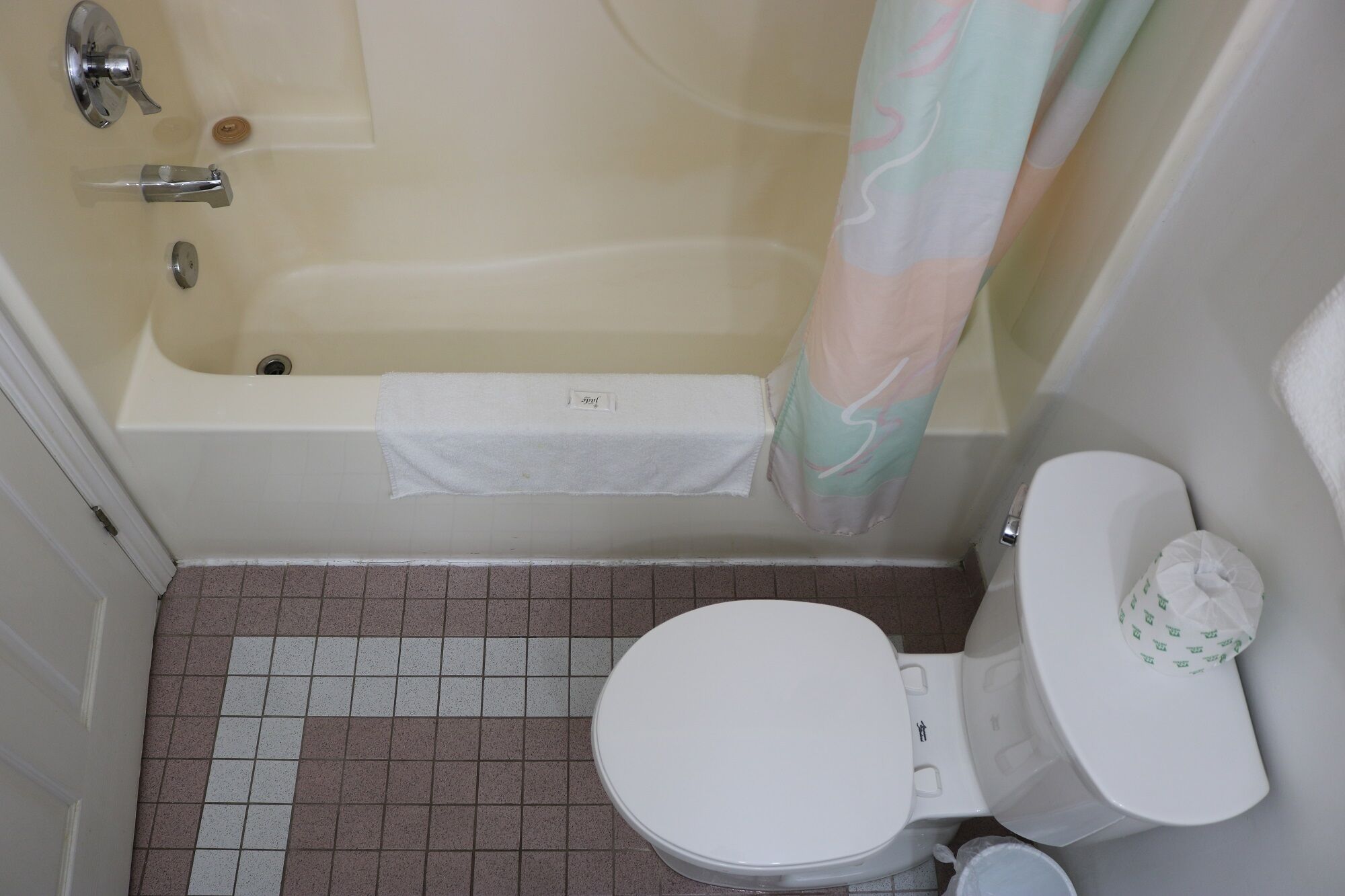 A bathroom with a bathtub, toilet, and a shower curtain.