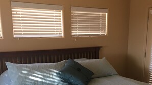 A bedroom with a bed, two windows with blinds, and a door. - Special Summer Rates 1-6 Months Begin April Near Restaurant & Shopping (Fountain Hills)