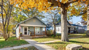 Un quartier résidentiel avec des maisons, un trottoir et des arbres aux feuilles d’automne.