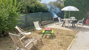 An outdoor patio with a barbecue grill, seating area, and a green table. - Appartement T3, Jardin, Parking (Chaponost)