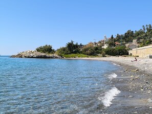 A beach with clear water, a rocky shoreline, and buildings in the background. - Apartment 'Gli Orti Sul Mare 1' with Sea View, Wi-Fi and Air Conditioning (Bordighera)