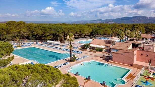 A resort with multiple swimming pools, lounge areas, and a mountainous backdrop. - Mobile Home 'Mobilhome Oasis Village Puget Argen' with Shared Pool and Private Terrace (Puget-sur-Argens)