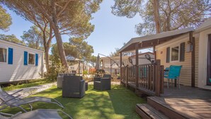 A deck with outdoor furniture, a covered area, and a grassy yard. - Mobile Home 'Mobilhome Oasis Village Puget Argen' with Shared Pool and Private Terrace (Puget-sur-Argens)