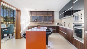 Una cocina moderna con comedor, ventanas amplias y electrodomésticos integrados.