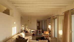 Un salon moderne avec un canapé, une table à manger et un escalier.