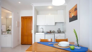 Una cocina moderna con armarios blancos, una mesa de comedor de madera y un mantel individual azul.