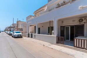 A row of parked cars along a street with a building featuring balconies and a fan on the exterior wall. - Holiday Home 'A Pochi Passi Dalla Spiaggia' with Air Conditioning (Ugento)